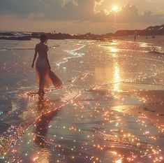 a woman walking on the beach at sunset with her dress blowing in the wind and sparkling water