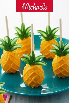 small pineapples with toothpicks in them on a blue plate and the words, michael's