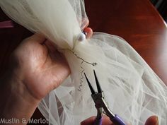 someone cutting fabric with scissors on a table