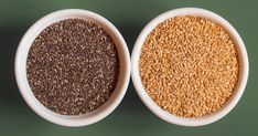 two white bowls filled with different types of grains on a green surface, one containing sesame seeds and the other containing flax