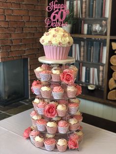 a tiered cupcake display with pink and white frosting