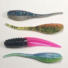 three different types of fishing lures on a white surface with black and blue speckles