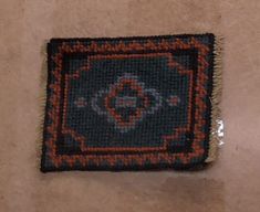 a piece of cloth with an orange and black design on it sitting on the floor