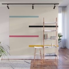 a living room with white walls and wooden flooring is furnished with an abstract wall mural