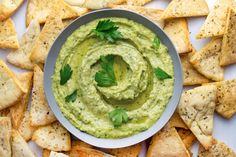 a bowl of guacamole surrounded by tortilla chips