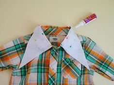 the shirt is made out of plaid fabric and has two pieces of paper taped to it