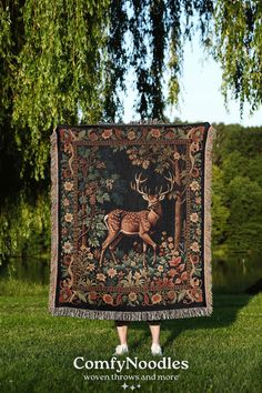 a deer tapestry hanging from the side of a tree