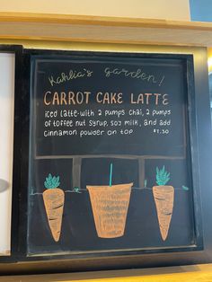 a sign with carrots drawn on it in front of a storefront window that says carrot cake latte