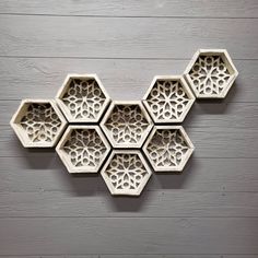 an intricately designed wall decoration on the side of a wooden wall, with four hexagonal holes cut into it