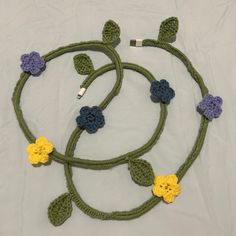 a crocheted green cord with flowers on it