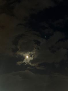 the full moon is shining brightly in the dark night sky over some buildings and trees