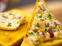 two pieces of bread with cheese and bacon on them sitting on a table next to each other