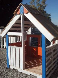 there is a small child's play house made out of pallets and wood