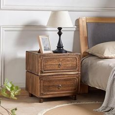 a bed room with a neatly made bed and a night stand on the side table