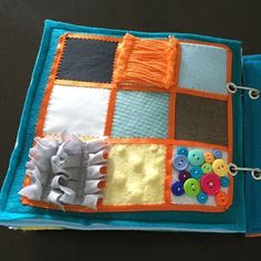 an open book with buttons and thread on it