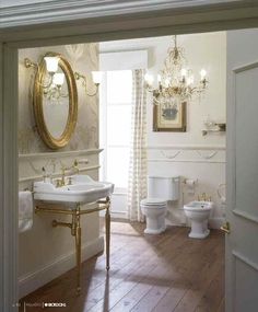 an open door leading to a bathroom with chandelier