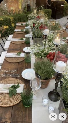 a long table is set with place settings and flowers