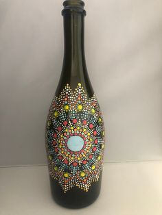 a black bottle with colorful designs painted on it