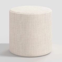 a white round ottoman sitting on top of a floor