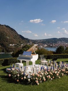 a white piano sitting on top of a lush green field