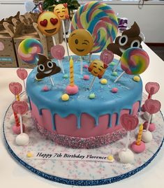 a birthday cake decorated with lollipops, candies and smiley face faces