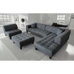 a large gray couch sitting on top of a white rug next to a chair and ottoman