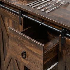 an open drawer with utensils on top of it next to a knife, fork and spoon