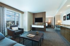 a living room filled with furniture and a flat screen tv mounted to the side of a wall