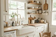 a kitchen filled with lots of white appliances and wooden shelves next to a large window