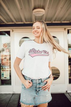 a woman standing in front of a store with her hands on her hips and smiling