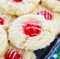 cookies with white icing and cherries on them