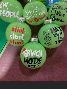 six green christmas ornaments with sayings on them