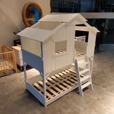 there is a doll house made out of wood and white paint on the bottom bunk