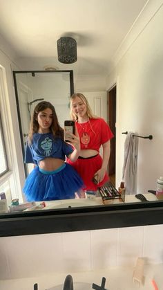 two young women standing in front of a bathroom mirror