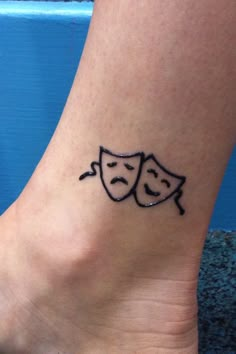 a couple of masks tattoo on the ankle