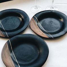 three black plates sitting on top of a white table