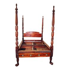 a wooden bed with four posts and drawers