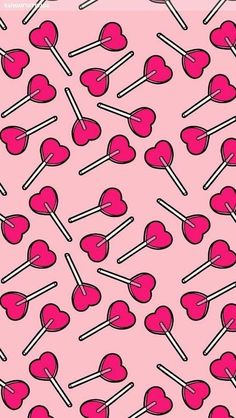 pink lollipops are arranged in the shape of hearts and sticks on a pink background