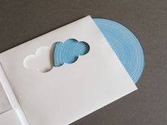 a white envelope with blue and white paper cut out to look like clouds on it