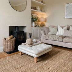 a living room filled with furniture and a fire place under a mirror on the wall