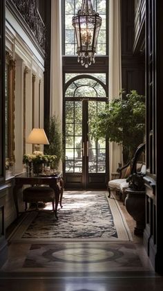 an entry way with a chandelier hanging from the ceiling and two lamps on either side