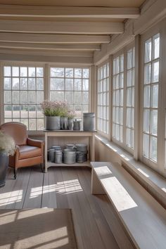 the sun shines through the windows into a room with wooden flooring and large potted plants