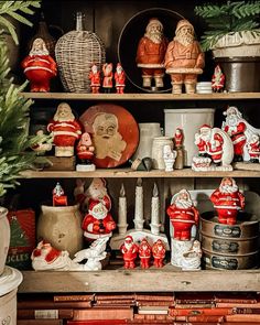 a shelf filled with lots of red and white figurines on top of wooden shelves