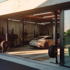 a white car parked in front of a garage with lots of equipment on the wall