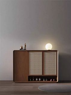 a wooden cabinet sitting on top of a hard wood floor next to a white wall