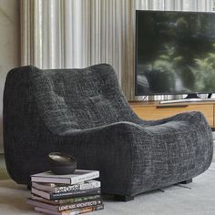 a grey chair sitting in front of a flat screen tv