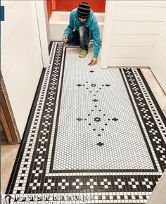 a man kneeling down on the ground in front of a door with a black and white tile floor