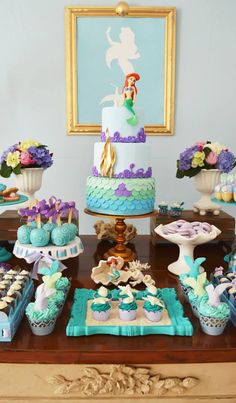 a table topped with cakes and cupcakes covered in frosting