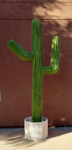 a large green cactus sitting on top of a cement planter