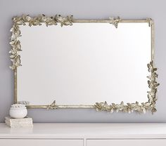 a mirror sitting on top of a white dresser